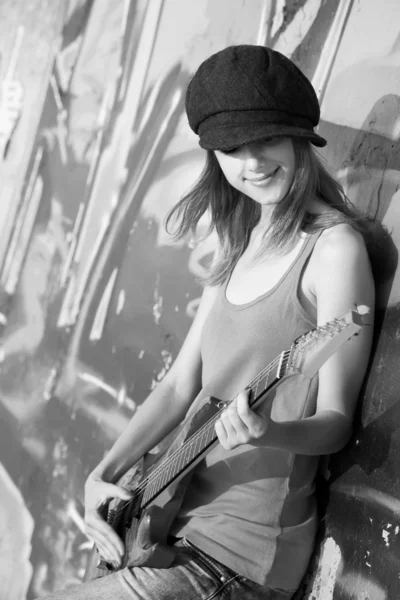 Beautiful girl with guitar and graffiti wall at background — Stock Photo, Image