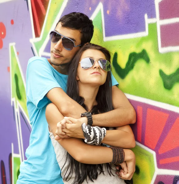 Jeune couple près de fond de graffiti — Photo