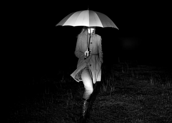 Girl with umbrella at night in lights.