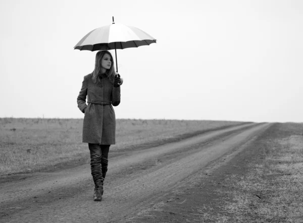 伞在乡村道路的寂寞女孩. — 图库照片