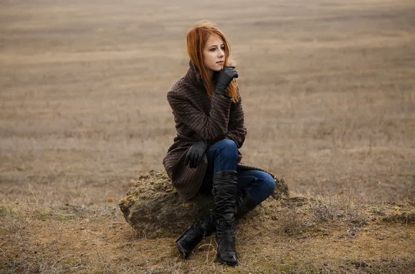 Redhead girl sitting at outdoor in autumn time. — Stock Photo, Image