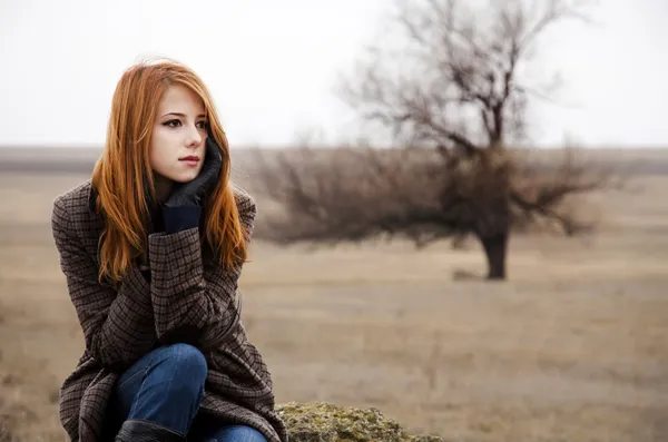 红发女孩坐在室外的秋天时间. — 图库照片