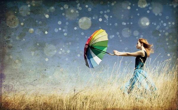 Chica pelirroja con paraguas en el prado de hierba ventosa. Foto en c antiguo —  Fotos de Stock