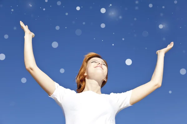 Porträtt av rödhåriga flicka i vitt med öppna händer på blå himmel — Stockfoto