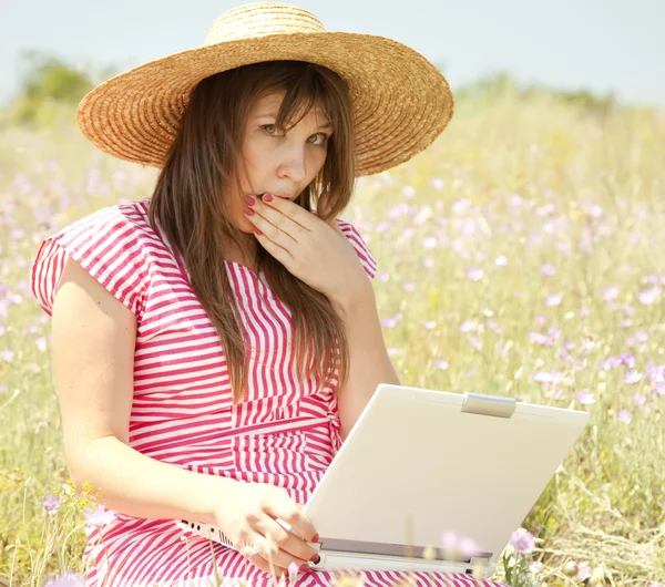 コンピューターが付いている公園で帽子の美しいブルネットの少女. — ストック写真