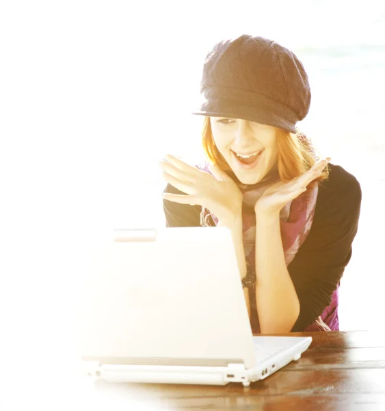 Porträt eines rothaarigen Mädchens mit Laptop und Rücklicht. — Stockfoto