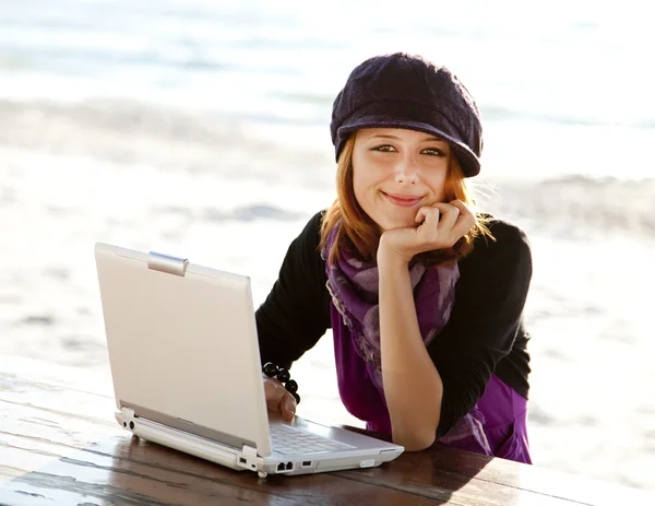 Retrato de menina de cabelos vermelhos com laptop na praia . — Fotografia de Stock