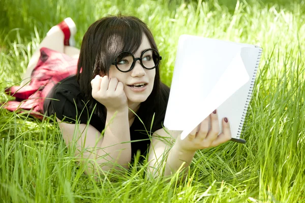 Jovem menina adolescente com notebook na grama verde . — Fotografia de Stock
