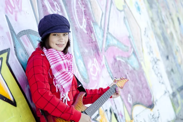 Retrato de close-up de uma jovem feliz com guitarra e graffiti — Fotografia de Stock