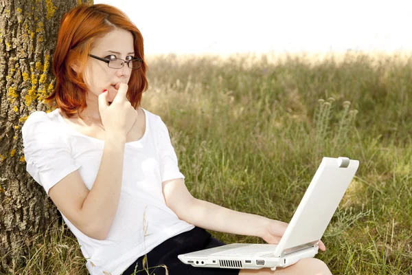 Jonge lachende mode meisje in glazen en laptop zitten in de buurt van — Stockfoto