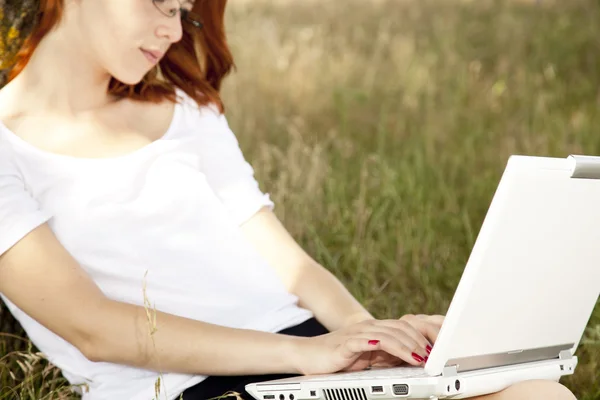 Jonge lachende mode meisje in glazen en laptop zitten in de buurt van — Stockfoto