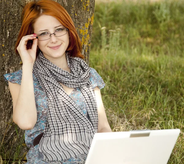 Giovane ragazza sorridente moda in occhiali e notebook seduto vicino — Foto Stock