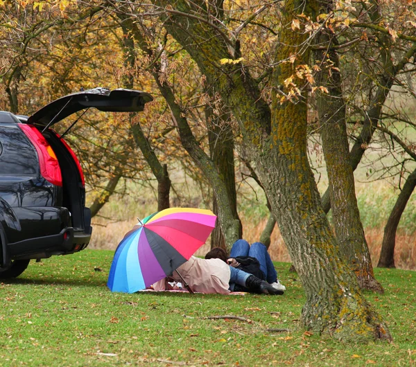 Couple lying near car at outdoor. — Stock Photo, Image