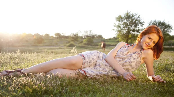 Dziewczyna w zielonej trawie pole zachód słońca. — Zdjęcie stockowe