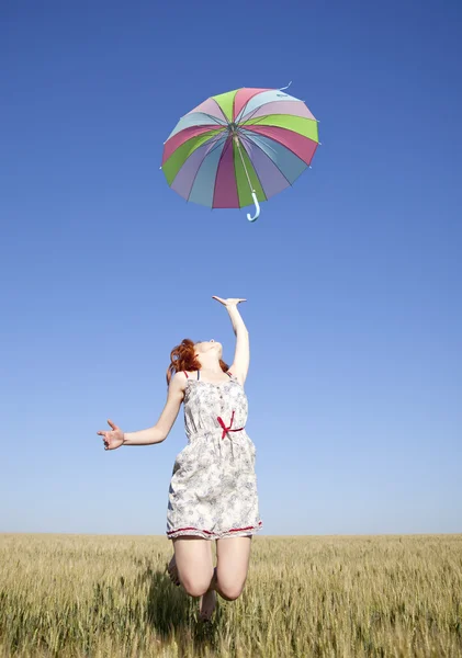 フィールドでジャンプ傘を持つ少女 — ストック写真