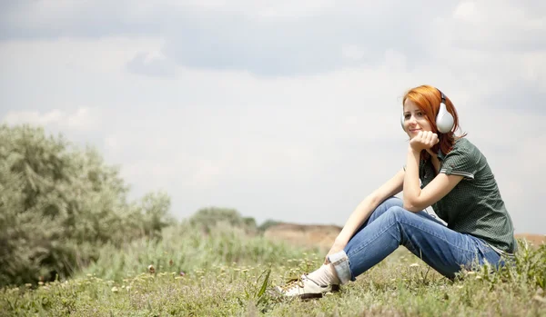 Genç Moda kız Rock lake yakınlarında kulaklıklarla. — Stok fotoğraf