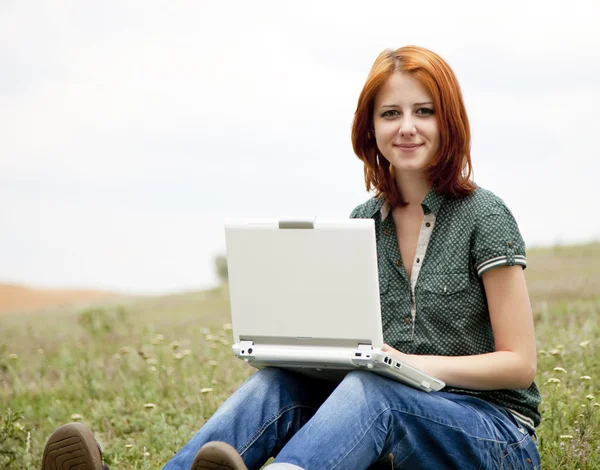Roodharige meisje met laptop buiten. — Stockfoto