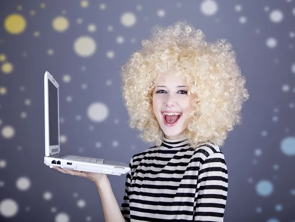 Portrait de fille drôle en perruque blonde avec ordinateur portable . — Photo
