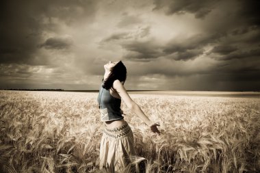 Girl at wheat field. Photo in dark colors with little noise. clipart