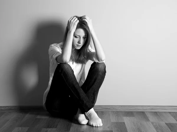 Ledsen tonåring tjej på golvet nära vägg. — Stockfoto