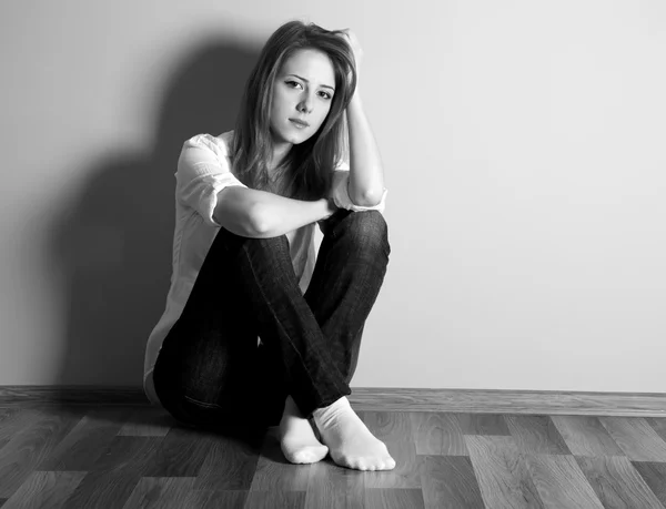 Triste menina adolescente no chão perto da parede . — Fotografia de Stock