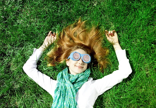 Girl lies at green grass in the park. — Stock Photo, Image