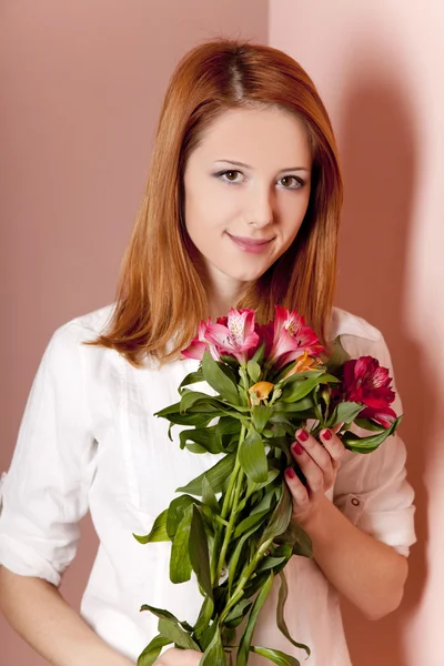 Rødhåret jente med blomster innendørs . – stockfoto