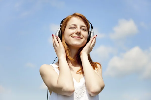 Young smiling girl with headphones and notes around her. — Stock Photo, Image