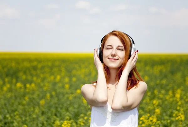 Redhead girl with headphone at field. — Stock Photo, Image