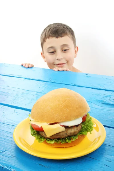 Мальчик и гамбургер — стоковое фото