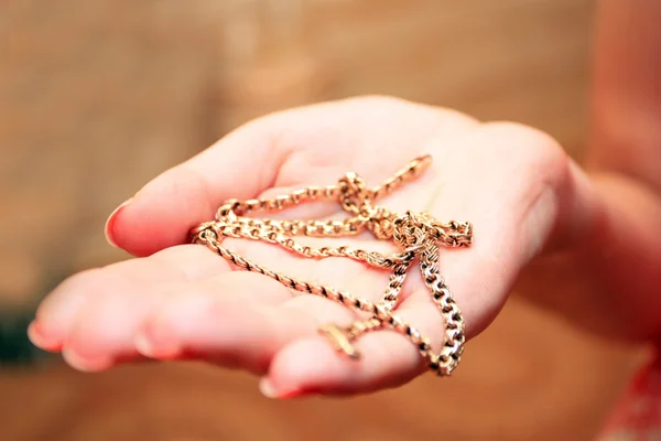 Gold chain on a palm — Stock Photo, Image