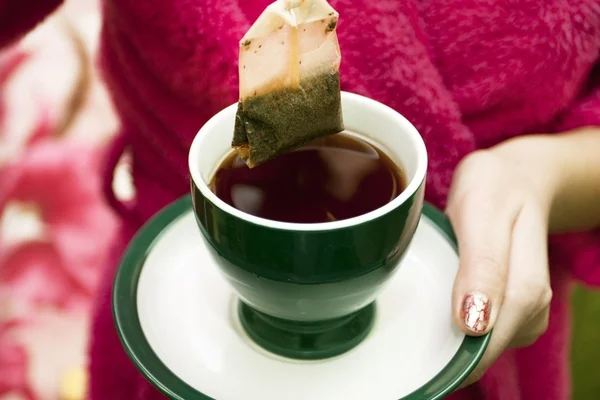 Sachet de thé avec une tasse de thé — Photo