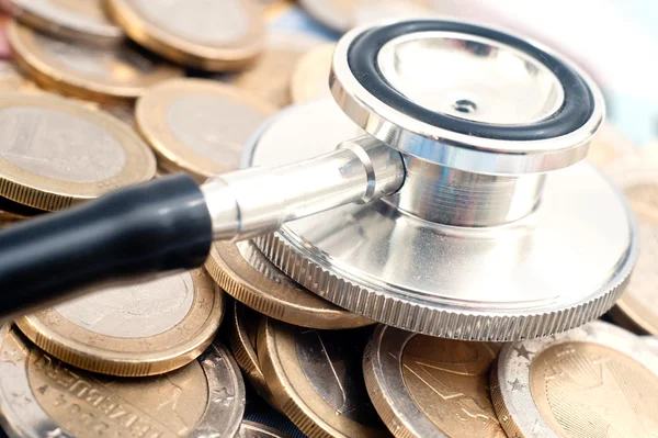 Conceito de cuidados de saúde caros com moedas, notas e estetoscópio — Fotografia de Stock