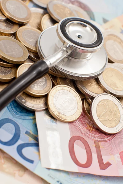Koncepcja drogie opieki zdrowotnej z monet, notatki i stetoskop — Zdjęcie stockowe