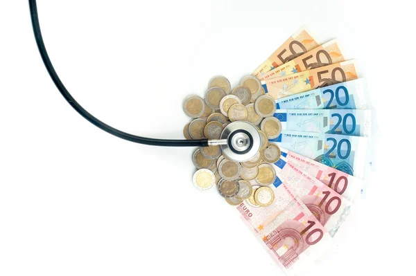 Concetto di assistenza sanitaria costosa con monete, banconote e stetoscopio — Foto Stock