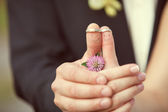 Wedding rings on her fingers painted with the bride and groom, f