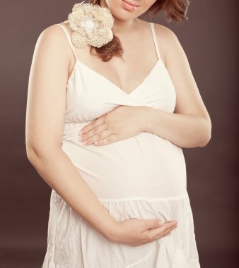 Beyaz elbiseli hamile kadın.