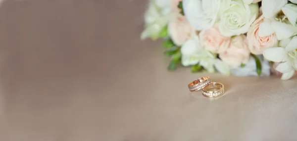 Pembe ve beyaz düğün buketi ve alyanslar. — Stok fotoğraf