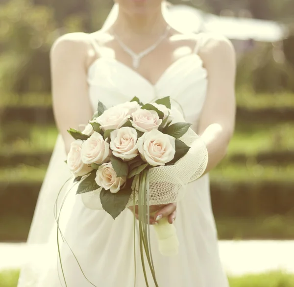 Rosa och vit bröllop bukett med rosor i händerna på brid — Stockfoto