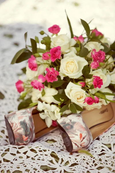 Rosa och vit bröllop bukett av rosor och brudkläder skor — Stockfoto
