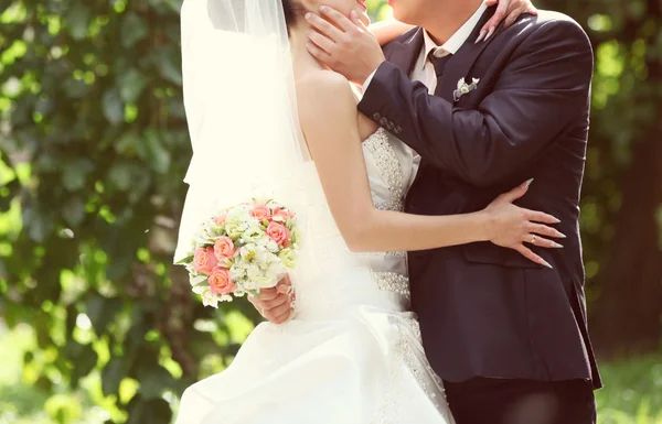 Růžové a bílé svatební kytice růží v rukou brid — Stock fotografie