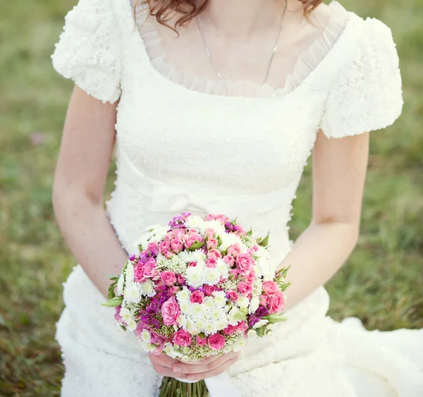 Buquê de casamento rosa e branco de rosas nas mãos da noiva — Fotografia de Stock