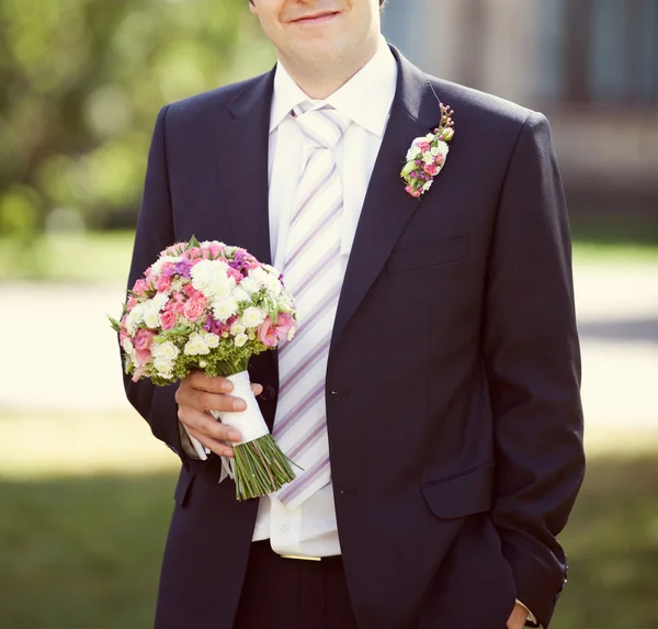 粉红和白色婚礼新郎手中的花束 — 图库照片
