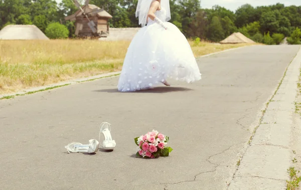 Bridal bouquet and shoes in the park and run away bride — Stock Photo, Image