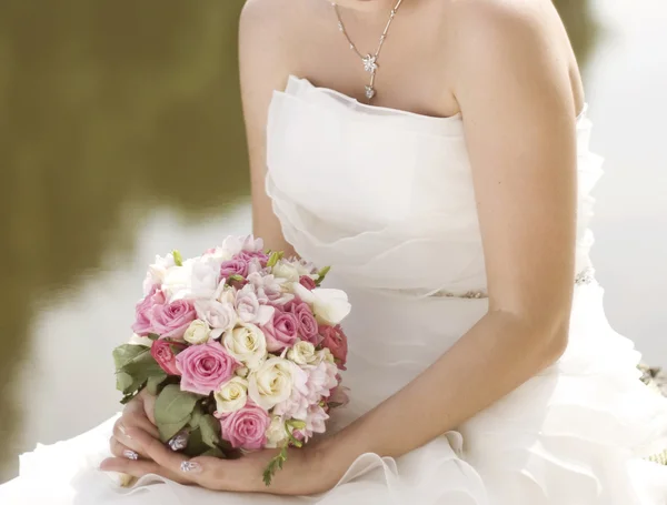 Roze en witte bruiloft boeket rozen in de handen van de brid — Stockfoto
