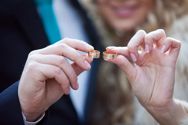 Обручальные кольца в руках жениха и невесты — стоковое фото