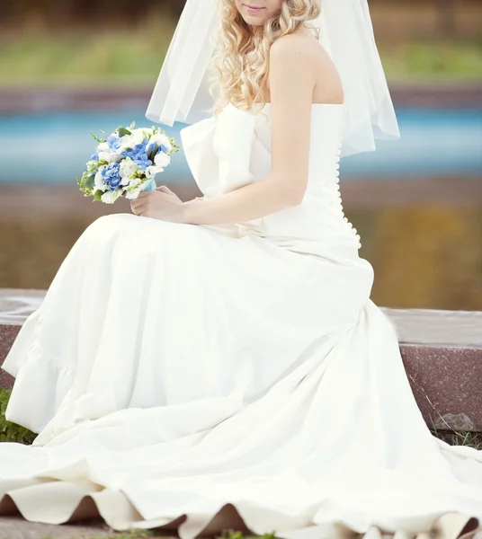 Bouquet da sposa di fiori bianchi e blu nelle mani dei bri — Foto Stock