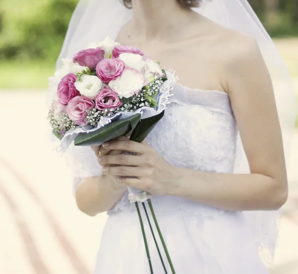 Buquê nupcial de flores brancas e rosa nas mãos do bri — Fotografia de Stock