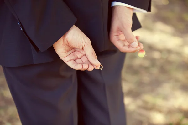 Brudgummen i en bröllop jacka med en vigselring i handen — Stockfoto