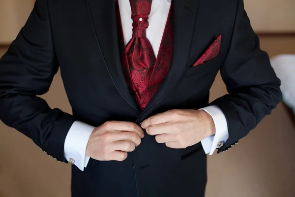 Groom in a wedding jacket and red tie — Stock Photo, Image